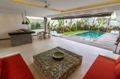 an open living room with a pool and a table at Villa Saha - Elegant 3-Bedroom in Seminyak in Seminyak