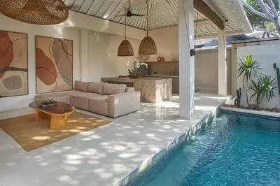 a living room with a couch and a swimming pool at Ahimsa Beach in Jimbaran