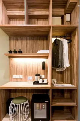 a kitchen with a wooden shelf with a microwave at Cara Cara Inn in Kuta