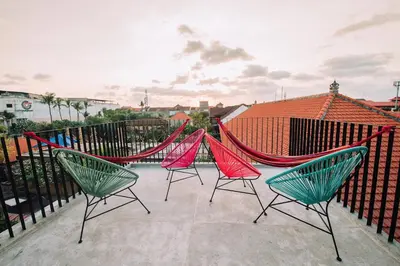 a group of chairs and hammocks on a patio at Cara Cara Inn in Kuta