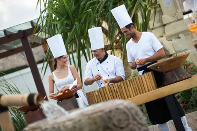 three people wearing chef hats standing next to a grill at Sadara Resort in Nusa Dua
