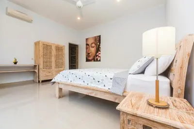 a bedroom with a bed and a table with a lamp at Castro Villa in Seminyak