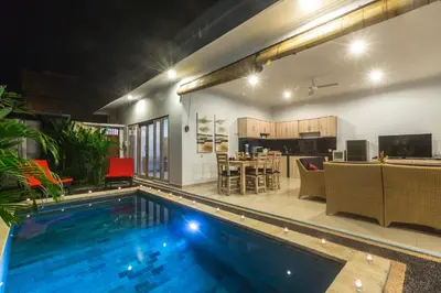 a swimming pool in the middle of a living room and a kitchen at Castro Villa in Seminyak