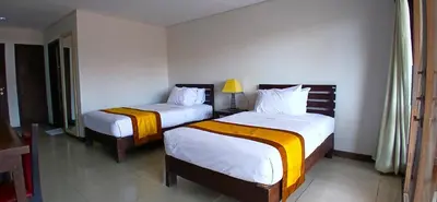 two beds in a hotel room with two beds at Nirmala Hotel & Convention Centre in Denpasar