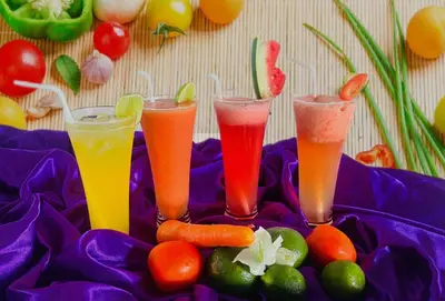 three drinks on a purple plate with fruits and vegetables at Nirmala Hotel & Convention Centre in Denpasar