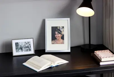 a desk with an open book and a picture and a lamp at Amarin Seminyak in Seminyak