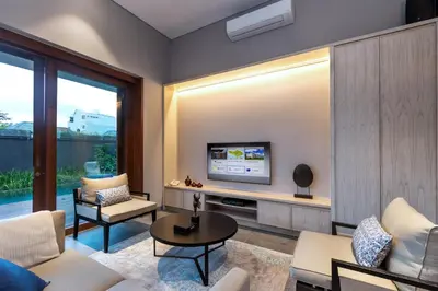 a living room with a tv on a wall at Amarin Seminyak in Seminyak