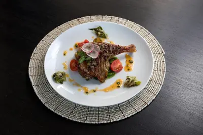 a plate of food with meat and vegetables on a table at Amarin Seminyak in Seminyak