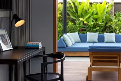a living room with a blue couch and a desk at Amarin Seminyak in Seminyak