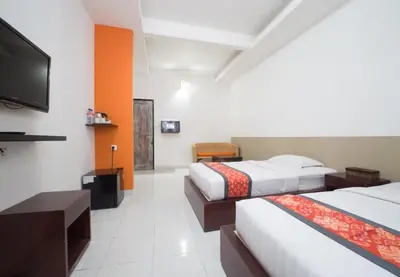 a hotel room with two beds and a flat screen tv at Adikara Renon in Denpasar