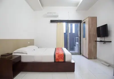 a bedroom with a bed and a flat screen tv at Adikara Renon in Denpasar
