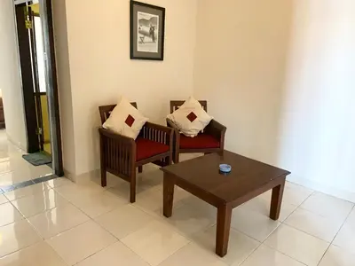 a living room with two chairs and a coffee table at Nirwana Suites in Denpasar