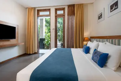a bedroom with a large bed and a tv at Pondok Sari Kuta in Kuta