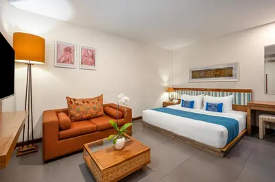 a hotel room with a bed and a couch at Pondok Sari Kuta in Kuta