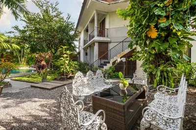 a group of white chairs in front of a building at Pondok Sari Kuta in Kuta