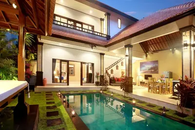 a house with a swimming pool in front of a house at Concetta Villa Seminyak Beachside By Bali Asia Villa in Seminyak