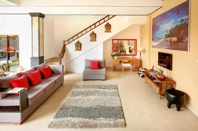 a living room with a couch and a staircase at Concetta Villa Seminyak Beachside By Bali Asia Villa in Seminyak