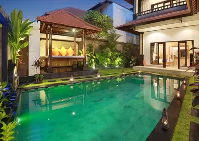 a swimming pool in front of a house at Concetta Villa Seminyak Beachside By Bali Asia Villa in Seminyak