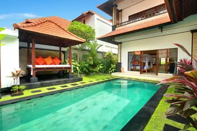 a villa with a swimming pool and a house at Concetta Villa Seminyak Beachside By Bali Asia Villa in Seminyak