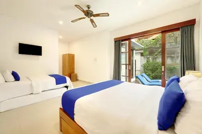 a bedroom with two beds and a ceiling fan at Lucia Villa Seminyak Beachside By Bali Asia Villa in Seminyak