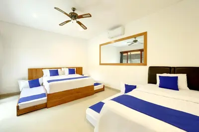 a bedroom with two beds and a ceiling fan at Lucia Villa Seminyak Beachside By Bali Asia Villa in Seminyak
