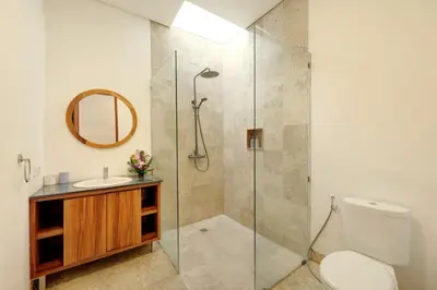 a bathroom with a shower and a toilet and a sink at Lucia Villa Seminyak Beachside By Bali Asia Villa in Seminyak