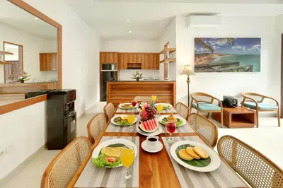 a dining room with a table with food on it at Lucia Villa Seminyak Beachside By Bali Asia Villa in Seminyak