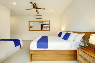 a bedroom with two beds and a ceiling fan at Lucia Villa Seminyak Beachside By Bali Asia Villa in Seminyak