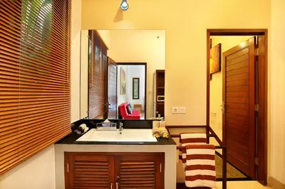 a bathroom with a sink and a mirror at De Liza Villa Seminyak Beachside By Bali Asia Villa in Seminyak