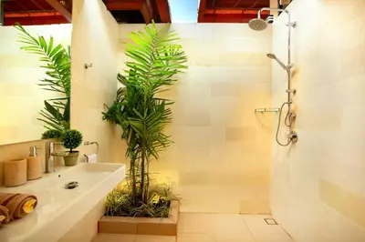 a bathroom with a sink and a shower with plants at De Liza Villa Seminyak Beachside By Bali Asia Villa in Seminyak