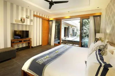 a bedroom with a large bed and a television at Villa the Hotman Paris I Seminyak in Seminyak