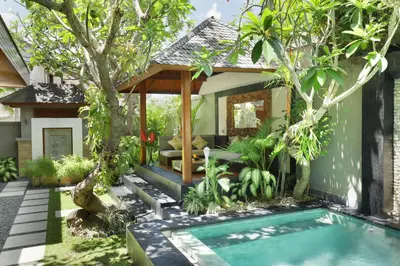 a garden with a swimming pool and a house at Villa the Hotman Paris I Seminyak in Seminyak
