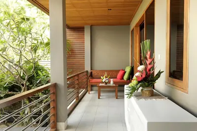 a porch of a house with a couch and flowers at Villa the Hotman Paris I Seminyak in Seminyak