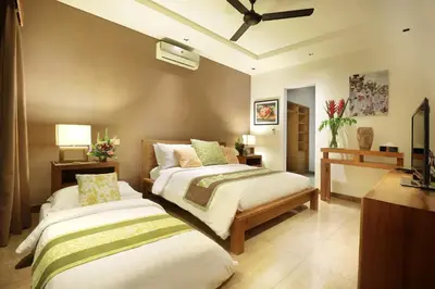 a bedroom with two beds and a ceiling at Villa The Hotman Paris II Seminyak in Seminyak