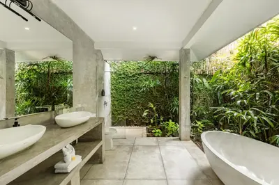 a bathroom with two sinks and a bath tub at Esha Villa Drupadi Seminyak in Seminyak