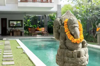 a statue of an elephant with flowers on its head next to a pool at Villa Khaleesi in Seminyak