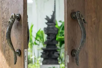 an open wooden door with rusty knockers on it at Villa Khaleesi in Seminyak