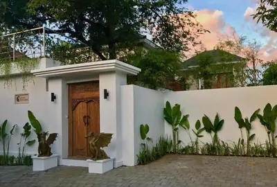 a white house with a wooden door at Villa Khaleesi in Seminyak