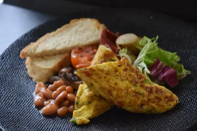 a plate of breakfast food with toast beans and vegetables at Sara Residence by Nakula in Legian