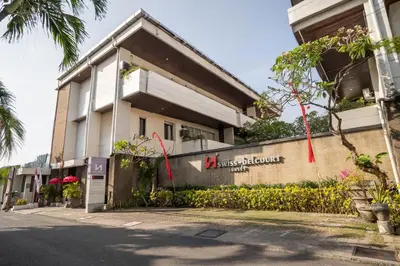 a building with a sign on the side of it at Swiss-Belcourt Sunset in Seminyak