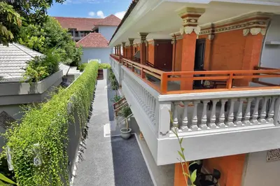 an external view of a house with a balcony at Dewi Sri Hotel in Legian