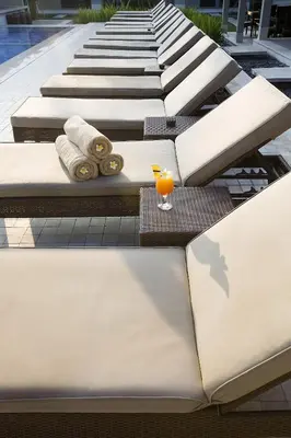 a row of tables with a glass of orange juice at Dewi Sri Hotel in Legian