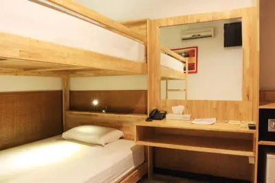 a room with two bunk beds and a desk at Hotel Karthi Kuta in Kuta