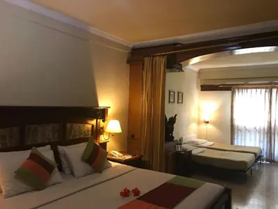 a hotel room with two beds and a window at Melasti Beach Resort & Spa Legian in Legian