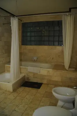 a bathroom with a tub and a toilet and a sink at Melasti Beach Resort & Spa Legian in Legian