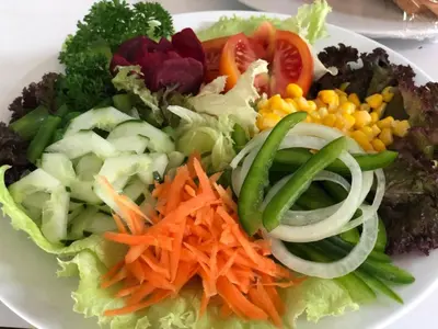 a plate of salad with carrots and other vegetables at Melasti Beach Resort & Spa Legian in Legian