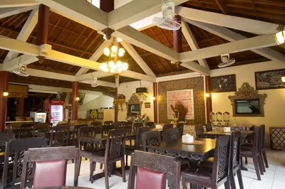 a dining room with tables and chairs in a restaurant at Bakung Sari Resort in Kuta