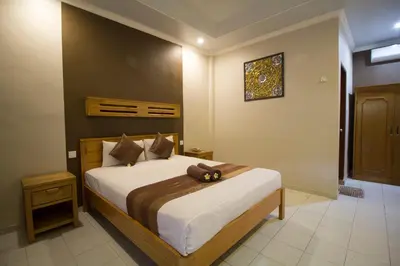 a bedroom with a bed with a teddy bear on it at Bakung Sari Resort in Kuta