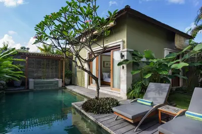 a villa with a pool and a house at Pradha Villas Seminyak in Seminyak