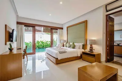 a bedroom with a large bed with a large mirror at Pradha Villas Seminyak in Seminyak